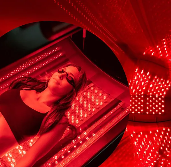 A woman lying in a red light therapy bed