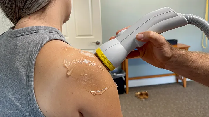 A patient receiving softwave therapy on her shoulder